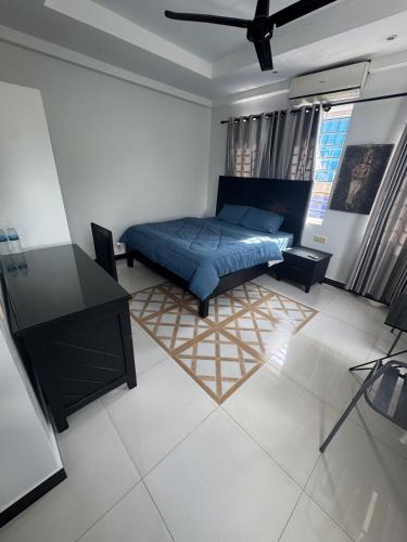 a bedroom with a bed and a desk in it at Villa de Sancho in Phumĭ Réach Born (2)