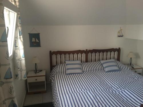 a bedroom with a bed with blue and white stripes at Apartment Gigi in Jadranovo