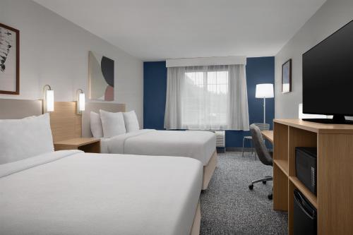 a hotel room with two beds and a flat screen tv at Spark by Hilton Washington Meadowlands Blvd in Washington