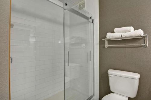 a bathroom with a shower with a toilet and towels at Hilton Garden Inn Oshkosh in Oshkosh