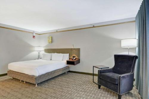 a bedroom with a bed and a chair at Hilton Garden Inn Oshkosh in Oshkosh
