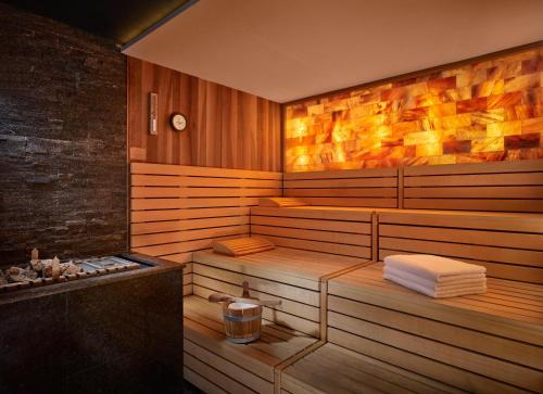 a sauna with wooden walls and a tub with towels at Grand Hyatt Abu Dhabi Hotel & Residences Emirates Pearl in Abu Dhabi