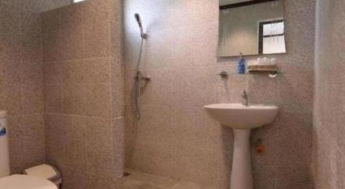 a bathroom with a shower and a sink and a toilet at Greenfield Valley Fishing Resort in Hua Hin