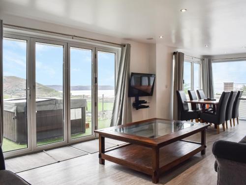 een woonkamer met een tafel, stoelen en een televisie bij Oceans Away - Uk48571 in Woolacombe