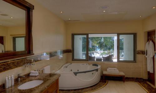 uma casa de banho com uma banheira grande e uma janela grande em Almanara Luxury Boutique Hotel and Villas em Praia de Diani