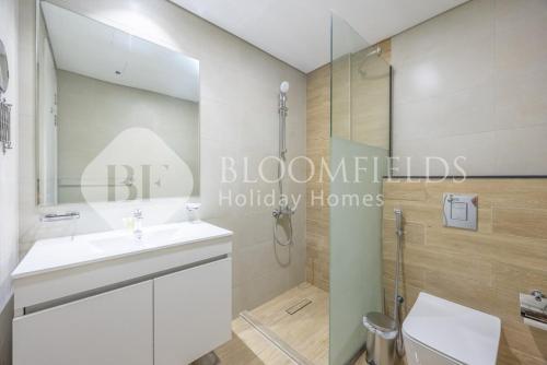a bathroom with a shower and a white sink at Bloomfields Executive 2BR Apt The Gate Masdar in Abu Dhabi