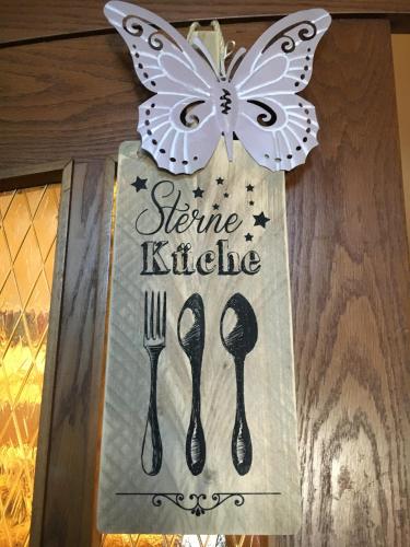 a butterfly sign on a door with a fork and spoon at Landgasthof Rössle ** Superior in Ruggell