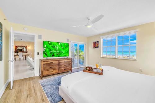 a bedroom with a large bed and a large screen tv at Ocean View Penthouse Retreat amenities: tennis court heated Pool Vista Key Two in Islamorada
