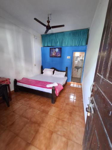 Laxmi في أرامبول: غرفة نوم بسرير وجدار ازرق