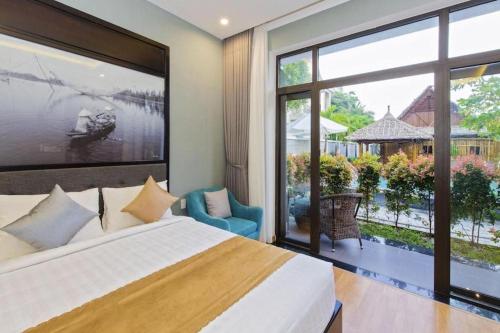 Un dormitorio con una cama y una ventana grande. en Friendly Villa Hoian, en Hoi An