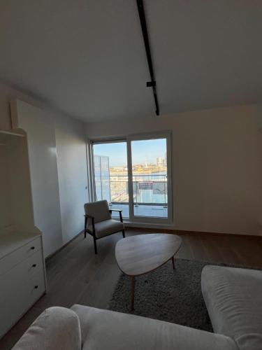 uma sala de estar com um sofá e uma cadeira em Luxurious apartment with feet in the sea & city em Ostend