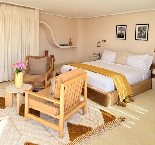 a bedroom with a large bed and a chair and a couch at Zen Zone Boutique Riad & Spa in Marrakesh