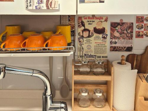 a kitchen sink with orange pots on a shelf at 샬롬 스테이 in Daegu
