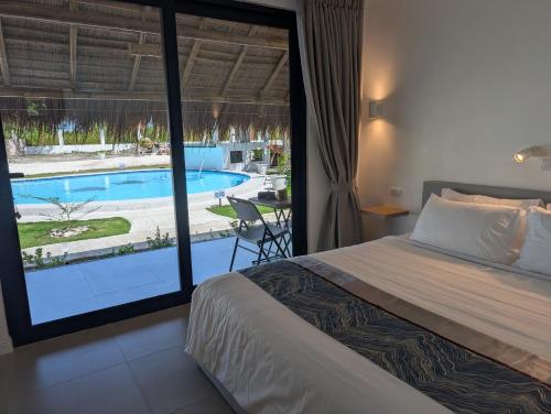 a bedroom with a bed and a view of a pool at Banana Beach Club in Moalboal