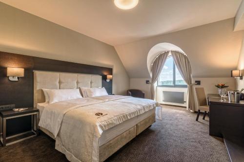 a bedroom with a large bed and a window at Hotel Victory in Brno