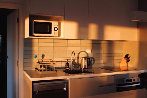 a kitchen with a sink and a microwave at The Yanakie House & Cabins in Yanakie