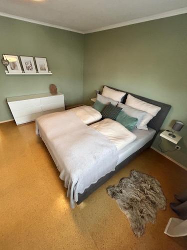 a bedroom with a large white bed with a rug at Antweiler Ferienwohnung in Bleialf