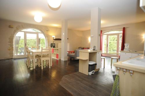a kitchen and living room with a table and chairs at Appartement La Poulotte in Couchey