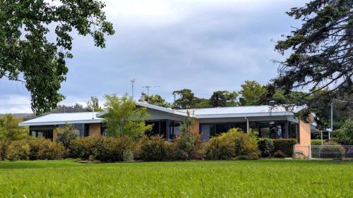 a building with a green field in front of it at wyeangta - Woodbridge Waterfront Retreat in Woodbridge