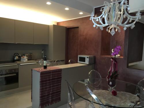 a kitchen with a glass table and a chandelier at L'Angolino Nascosto in Verona