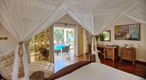 um quarto com uma cama, uma escrivaninha e uma mesa em Almanara Luxury Boutique Hotel and Villas em Praia de Diani