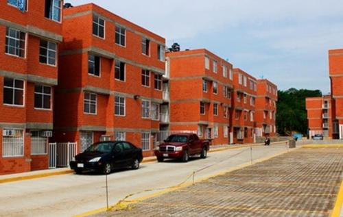 two cars parked on a street in front of brick buildings at Departamento Villas Doradas in Santa Cruz Huatulco