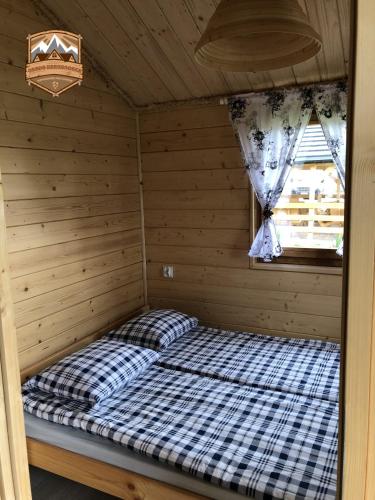 a bed in a room in a wooden cabin at Osada w Karkonoszach in Kowary