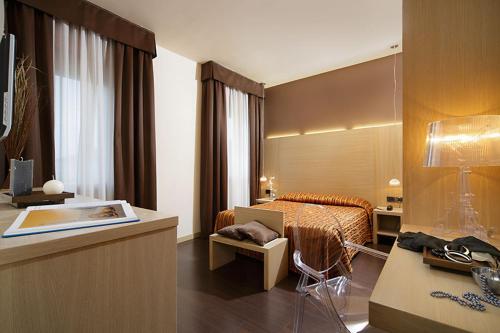 um quarto de hotel com uma cama e uma secretária em Hotel Paris em Mestre
