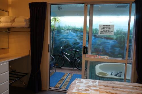 a room with a door with a tub and a bike outside at Ascot On Fenton in Rotorua