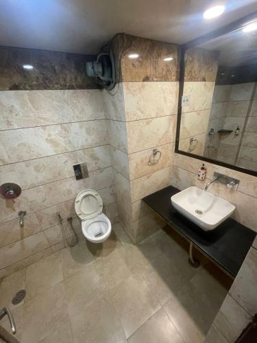 a bathroom with a toilet and a sink at Hotel Solitaire in Ambāla Cantonment