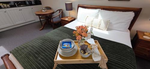 a bedroom with a bed with a tray with flowers on it at Sandstone Suites - In the heart of Port Fairy in Port Fairy