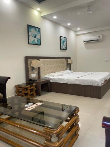 a room with a bed and a glass table at Hotel Solitaire in Ambāla Cantonment