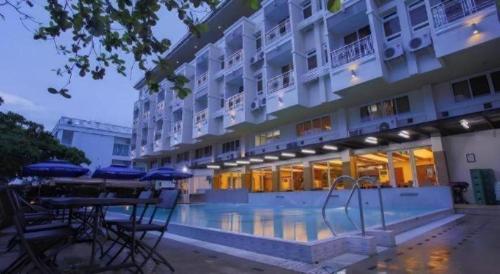 a hotel with a swimming pool in front of a building at Subic Grand Harbour Hotel Subic Bay in Olongapo