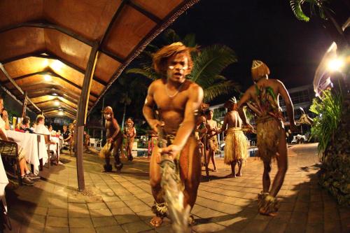 a group of people walking on a beach at night at The Melanesian Port Vila in Port Vila