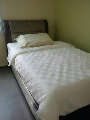a large bed with white sheets and pillows at E-Home Kulai in Kulai