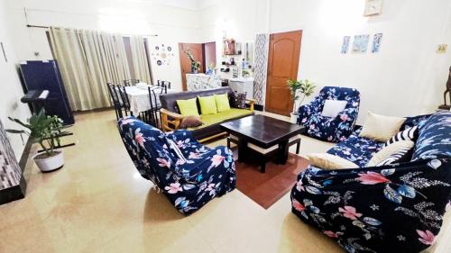 Tomato home stay في Tezpur: غرفة معيشة مع كرسيين وطاولة