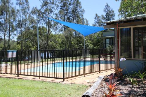 an iron fence around a pool with a blue tarp over it at Wooli River Lodges in Wooli