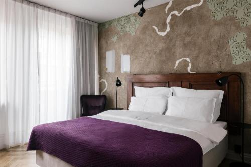 a bedroom with a large bed with a purple blanket at STORY HOTEL STOCKHOLM STUREPLAN, in JdV by Hyatt in Stockholm