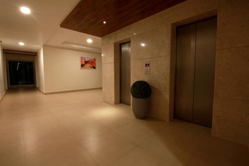 a hallway of a building with a plant in a vase at Palguni Residency in Hassan