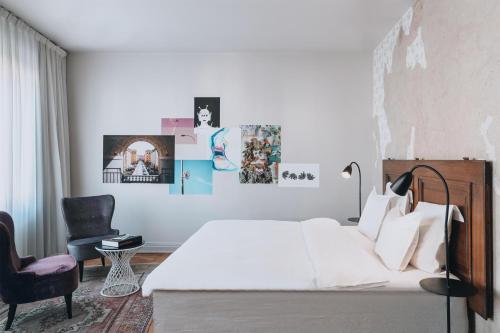 a white bedroom with a bed and a chair at STORY HOTEL STOCKHOLM STUREPLAN, in JdV by Hyatt in Stockholm