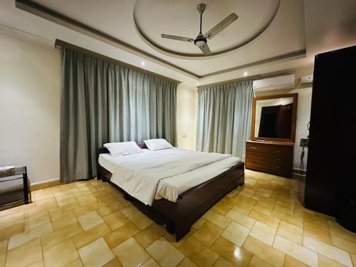 a bedroom with a large bed and a television at Vineyard Vacations in Cochin
