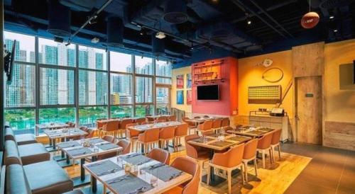 a restaurant with tables and chairs and large windows at Hotel COZi·Wetland in Hong Kong