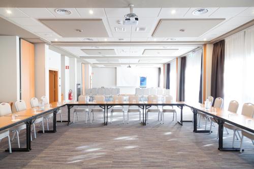 a conference room with a long table and chairs at Novotel Brescia Due in Brescia