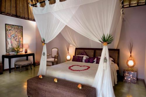 1 dormitorio con 1 cama con dosel en Cili Emas Oceanside Resort, en Tejakula