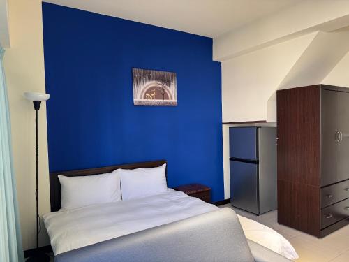 a bedroom with a blue wall and a bed at 台中向日葵 in Taichung