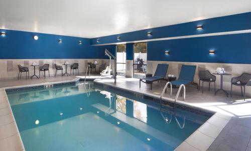 a pool in a hotel with chairs and tables at Hampton Inn Youngstown/Boardman in Poland