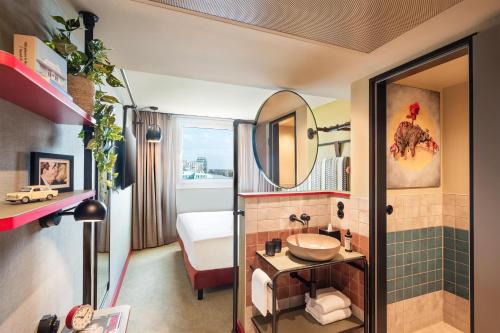 a bathroom with a sink and a mirror at Me and All Hotel Berlin East Side, by Hyatt - NEW OPENING in Berlin