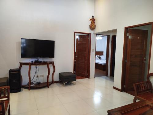 a living room with a flat screen tv on the wall at Matthew's Tranquil Homestay in General Luna