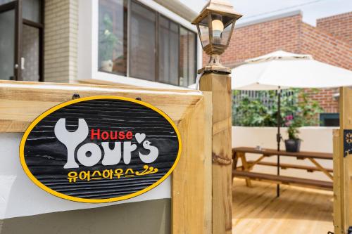 a sign for a house ours on a fence at Yours Guesthouse in Tongyeong in Tongyeong