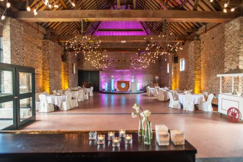 a banquet hall with white tables and white chairs at Hotel Schinvelder Hoeve in Schinveld